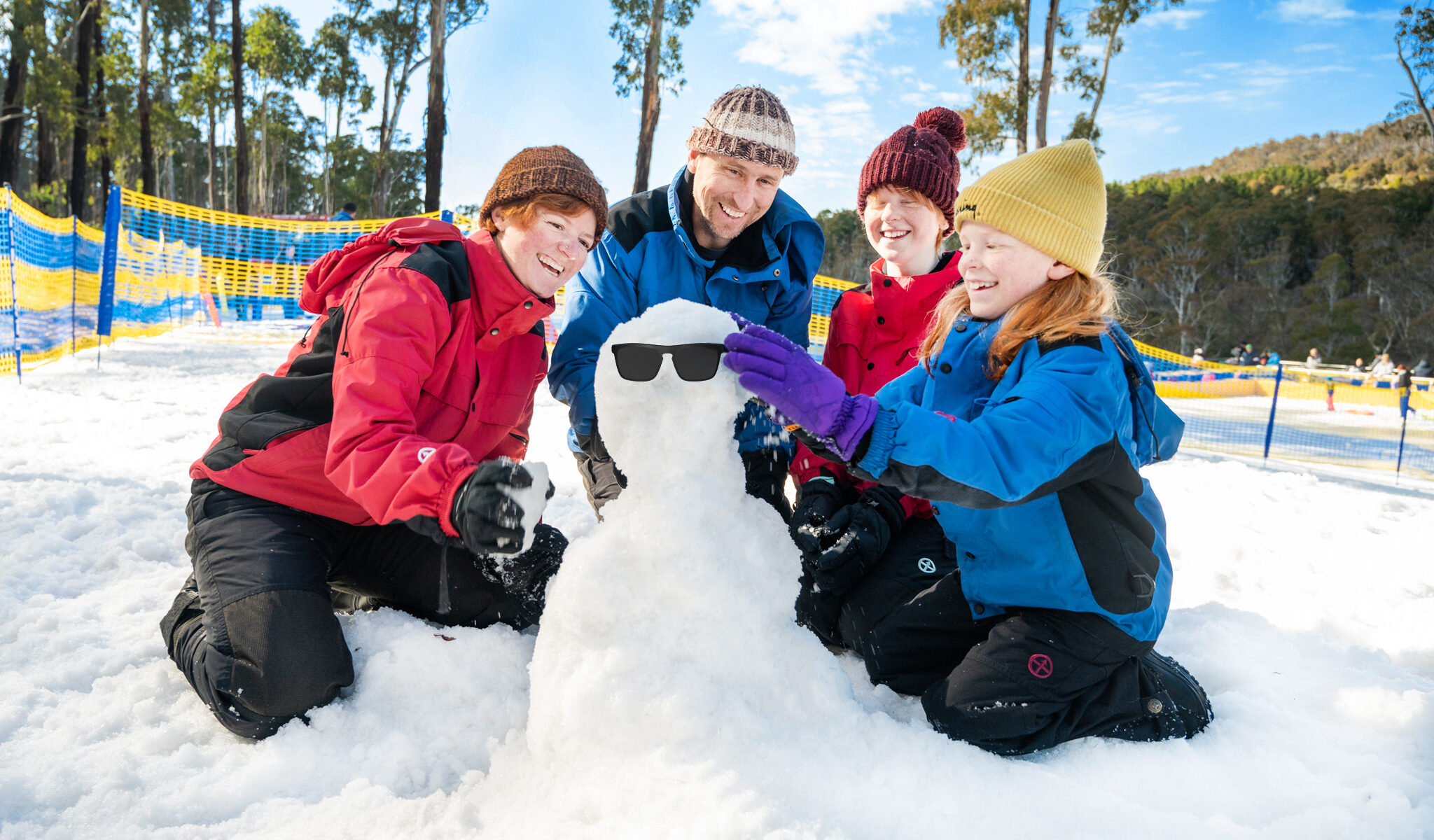 Family building a snowman at Corin Forest Snowplay