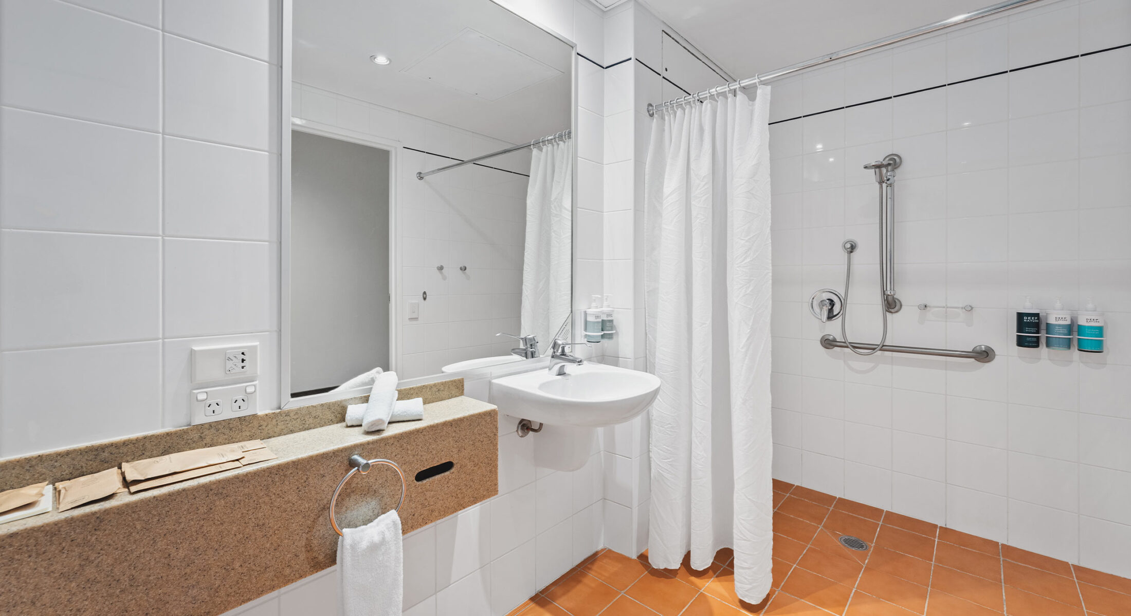 Novotel Canberra accessible room bathroom with rails in the shower